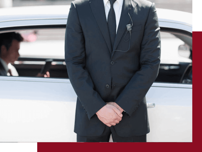 A man in suit and tie standing next to a white car.