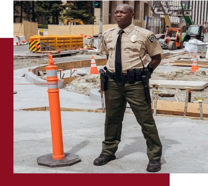 A police officer standing next to an orange cone.